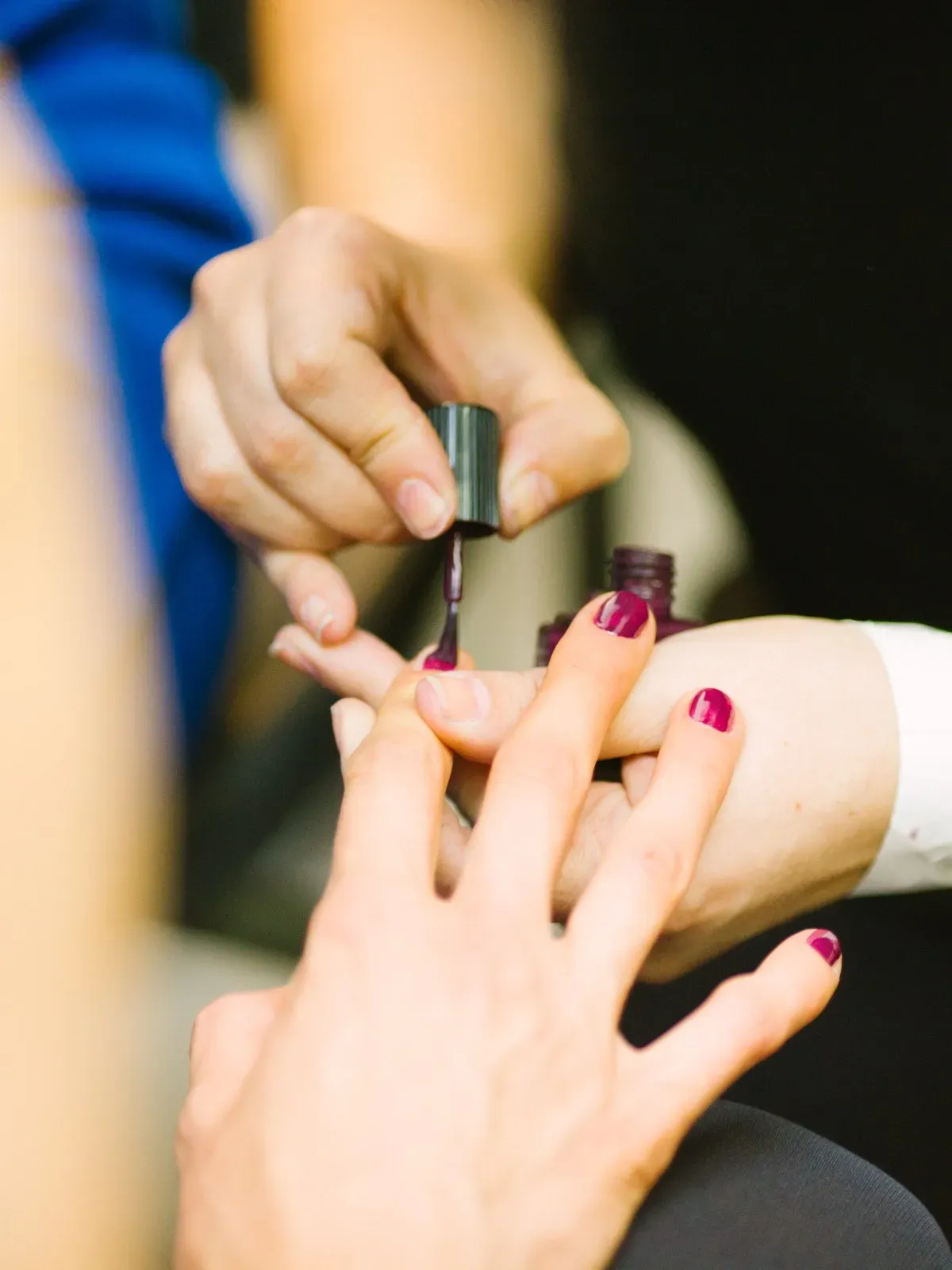 Manicurista aplicando esmalte en las uñas de una clienta