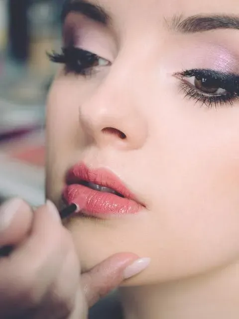 Maquilladora aplicando labial a una modelo